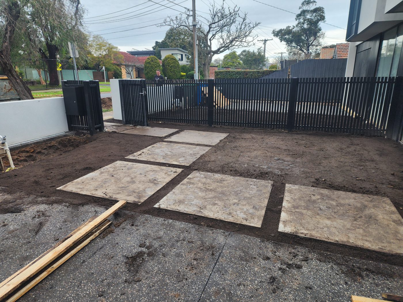 Paving in progress — Laying pavers by the fence